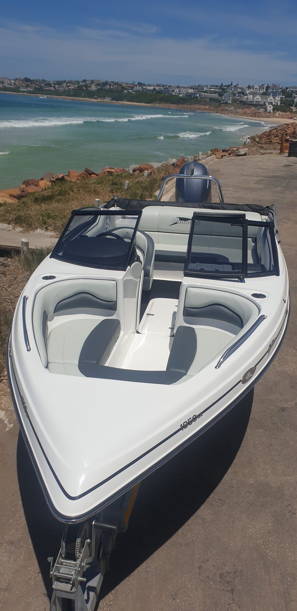 White boat on a dock with ocean and coastline in the background