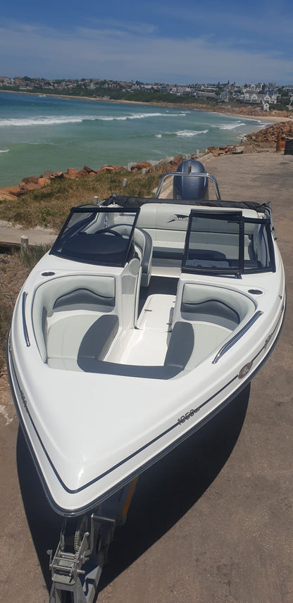 White boat on a dock with ocean and coastline in the background