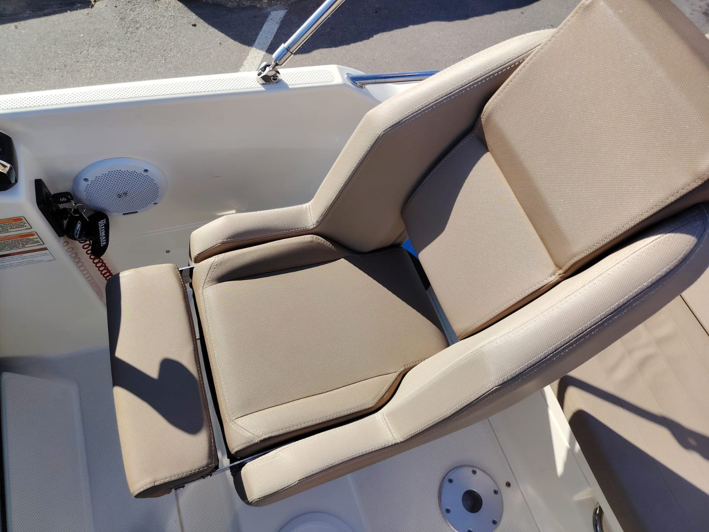 Beige cushioned seat on a boat with a white interior