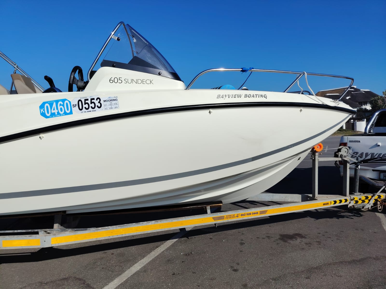 White speedboat on a trailer with a clear blue sky background