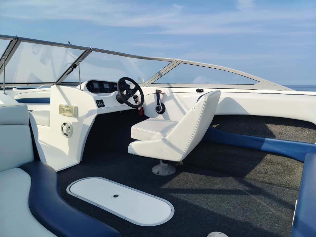 Blue and white Kestrel 575 boat with a Yamaha 150HP four-stroke outboard and trailer.