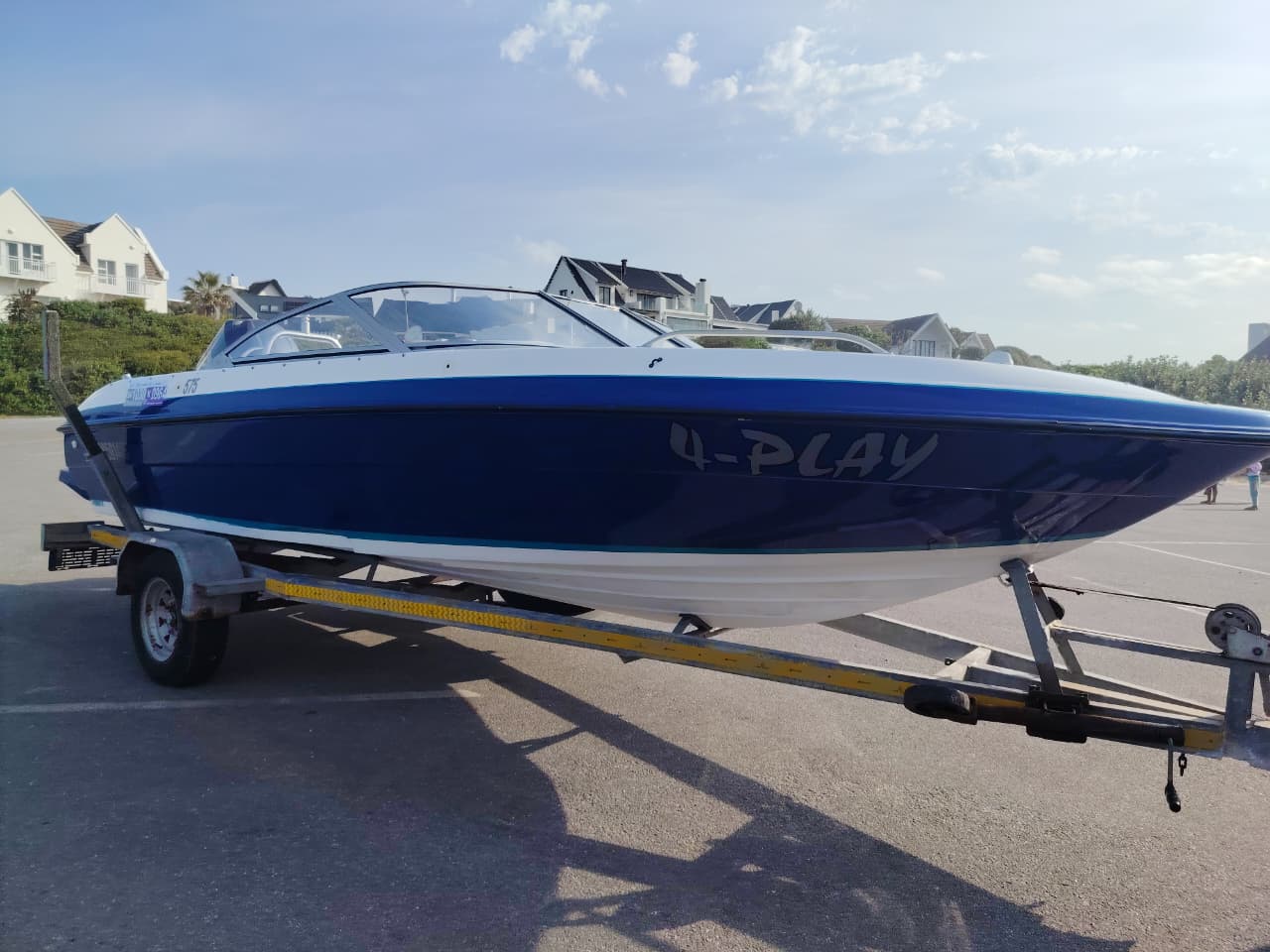 Blue and white Kestrel 575 boat with a Yamaha 150HP four-stroke outboard and trailer.